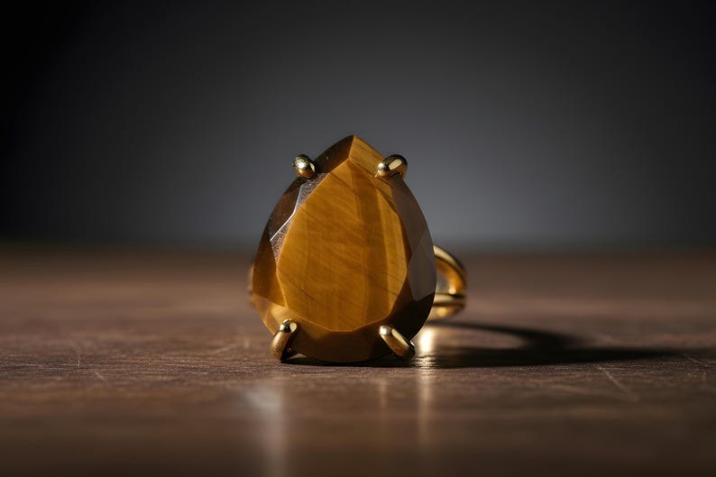 A large, yellow gemstone, possibly a diamond, is displayed on a wooden surface against a dark background.