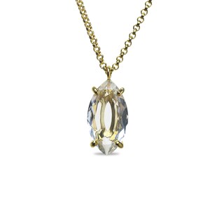 May include: A gold chain necklace with a clear marquise-shaped crystal pendant.