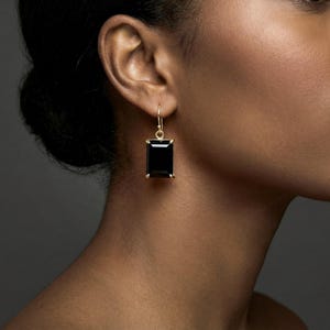 Może przedstawiać: Zestaw trzech ceramicznych kubków z nakrapianym, matowym wykończeniem. Kubki są w odcieniach kremu, jasnoszarym i ciemnoszarym. Każdy kubek ma prosty, minimalistyczny design.