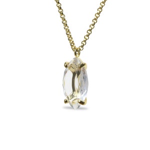May include: A gold chain necklace with a clear marquise-shaped crystal pendant.