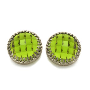 May include: A pair of green glass earrings with a silver filigree design.