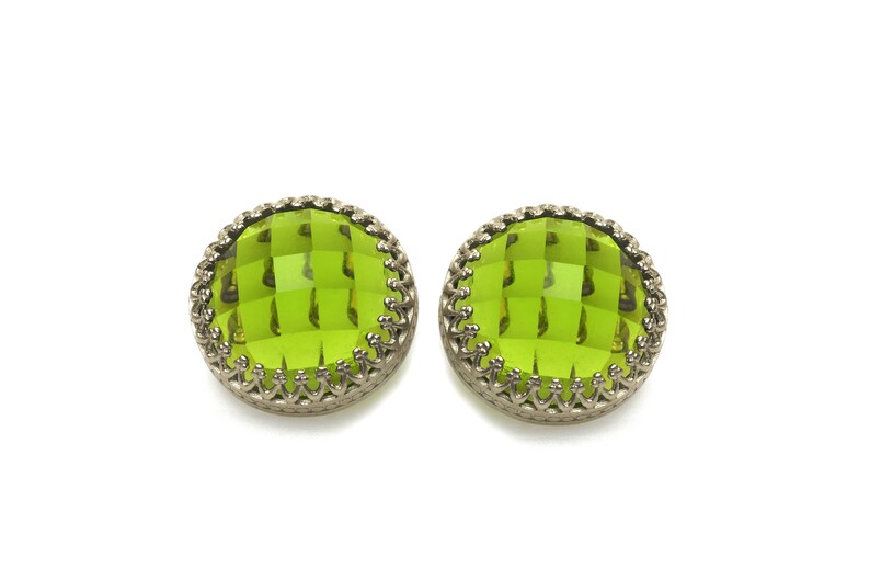May include: A pair of green glass earrings with a silver filigree design.