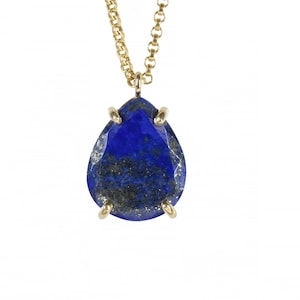 May include: A gold chain necklace with a teardrop-shaped lapis lazuli pendant. The pendant is set in gold and has a faceted cut.