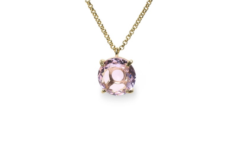 May include: A delicate gold chain necklace with a round, light purple gemstone pendant.