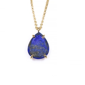 May include: A gold chain necklace with a teardrop-shaped lapis lazuli pendant.