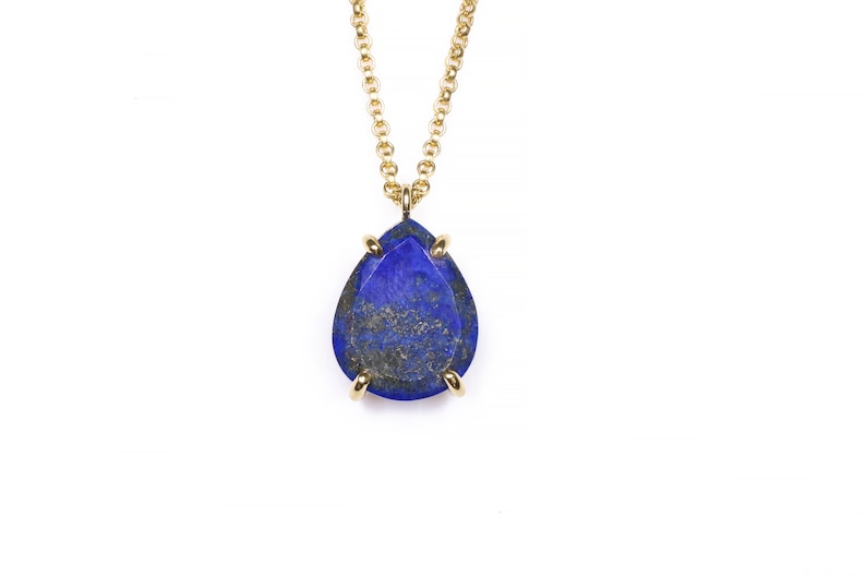 May include: A gold chain necklace with a teardrop-shaped lapis lazuli pendant.