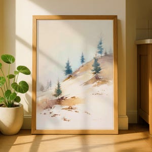 May include: A framed watercolor painting of a snowy hillside with evergreen trees. The artwork features a soft color palette of white, brown, and blue, and is displayed in a natural wood frame. The painting evokes a serene winter landscape.