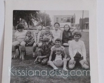 Vintage B&W photo of a group of 10 young girls on playground bench