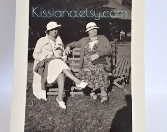 Two stylish women with attitude relaxing on bench--Vintage B&W photo