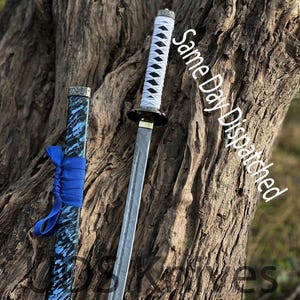 May include: A Japanese katana sword with a white and black handle, a silver blade, and a blue and black scabbard. The text "Same Day Dispatched" is visible on the image.