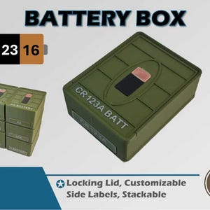 May include: An olive green battery box with the text "BATTERY BOX" at the top. The box has a rectangular shape with a lid and the text "CR123A BATT" on the side. A smaller box with "CR123 16" is also visible.