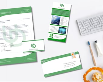 May include: A stationery set with a green and white design, including a letterhead, business card, and envelope. A promotional flyer is also present, along with a keyboard, pencils, and a toothbrush. The stationery features the "Universaenia Design" logo.