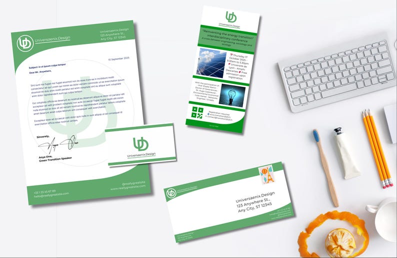 May include: A stationery set with a green and white design, including a letterhead, business card, and envelope. A promotional flyer is also present, along with a keyboard, pencils, and a toothbrush. The stationery features the "Universaenia Design" logo.