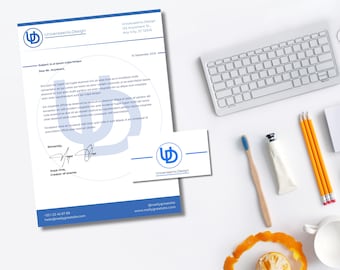 May include: A top-down view of a workspace featuring a letterhead, business card, keyboard, pencils, and a toothbrush. The letterhead and card display the "Universaenix Design" logo and contact information. A half-eaten orange sits near a white mug.