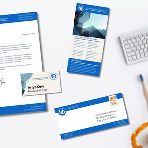 May include: A collection of business stationery, including a letterhead, business card, and envelope, featuring a blue and white design with the "Universaenix Design" logo. A keyboard, pencils, and other office supplies are also present.