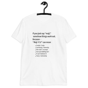May include: White t-shirt with black text. The text reads, "If you just say 'maji,' somehow things work out. Because... 'Maji マジ' can mean really/truly, seriously/honestly, for real?/no way!, are you kidding me?, I can't believe it, very/extremely."