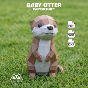 Pode incluir: Uma escultura de papel low-poly de um filhote de lontra com facetas geométricas castanhas e brancas. O texto BABY OTTER PAPERCRAFT aparece no topo, com ícones de ficheiros PDF, SVG e DXF à direita e o logótipo MINH MEO no canto inferior.