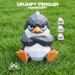 May include: A low-poly papercraft model of a grumpy penguin with a dark grey head, white chest, and orange beak and feet. The figure has crossed arms and a stern expression. Text reads GRUMPY PENGUIN PAPERCRAFT, PDF, SVG, DXF, and MINH MEO.