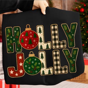 May include: Black fabric featuring the words "HOLLY JOLLY" in a festive design. The letters are decorated with Christmas ornaments, holly, and plaid patterns. The ornaments are red and green, with white accents. A Christmas tree is visible in the background.