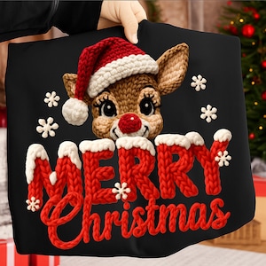 May include: Black Christmas-themed pillow featuring a knitted reindeer wearing a Santa hat. The words "MERRY Christmas" are displayed in red knitted letters with white accents and snowflakes. A festive holiday decoration.