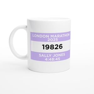 Puede incluir: Taza de cerámica blanca con asa curva. La taza presenta una etiqueta lavanda con el texto "LONDON MARATHON 2025", el número "19826", el nombre "SALLY JONES" y el tiempo "4:48:45".