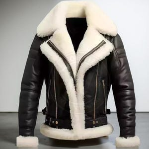 May include: Black leather jacket with a white shearling collar and lining. The jacket features a zip-up front, side pockets, and a buckled belt at the waist. The sleeves have a ribbed design and cuffs with white shearling trim. A classic outerwear piece.