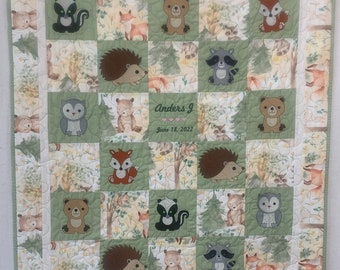 Woodland Animal Baby Quilt with embroidered animals and a personalized label