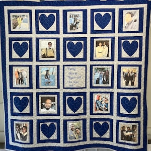 May include: A blue and white quilt with a heart pattern and framed photos of a family. The quilt has the text "Family: where life begins and love never ends" in the center.
