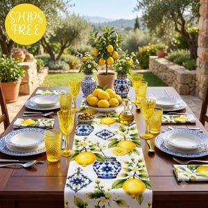 May include: A wooden dining table set with white plates featuring blue patterned rims, yellow textured glasses, and a table runner decorated with yellow lemons and blue floral motifs. A bowl of lemons sits in the center with two blue vases.
