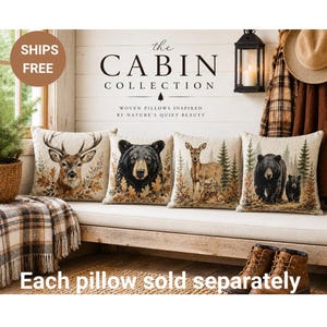 May include: Four square woven pillows featuring wildlife imagery including a deer head, a black bear head, a deer with a fawn in a forest, and a black bear with a cub in a forest. The pillows are displayed on a bench with text above reading The Cabin Collection.