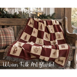 May include: A woven blanket featuring a checkered pattern in deep red and cream. The squares display various holiday-themed motifs including Santa Claus, pine trees, stars, bells, gifts, birds, candles, and horses, finished with a fringed edge.