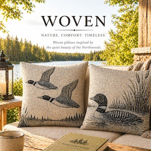May include: Two decorative woven pillows with black and white illustrations of loons and reeds. The pillows are on a beige couch with a blanket. The word "WOVEN" is at the top of the image.