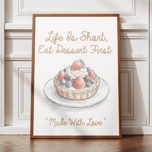 Peut inclure: Une affiche encadrée représentant une illustration dessinée à la main d'une tarte aux fruits avec des fraises et des myrtilles sur une assiette. Le texte indique Life Is Short, Eat Dessert First. en haut et Made With Love en bas.