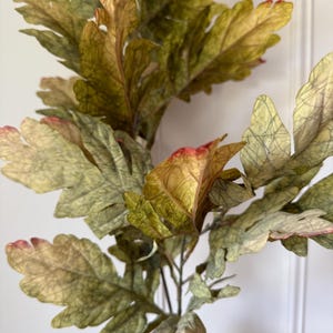 Peut inclure: Un bouquet de feuilles artificielles aux couleurs variées, notamment le vert, le jaune et le rouge. Les feuilles ont un aspect texturé et sont disposées sur des tiges, créant une esthétique naturelle. Idéal pour la décoration intérieure ou les projets d'artisanat.