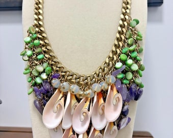 Collar babero tono dorado con colgantes de conchas marinas, piedras y cristales en cadena de eslabones estilo boho.