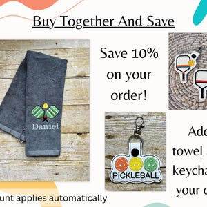 May include: A gray towel with embroidered pickleball paddles and the name "Daniel". Also shown are two pickleball paddle keychains and a keychain with three pickleball-colored circles and the word "PICKLEBALL".
