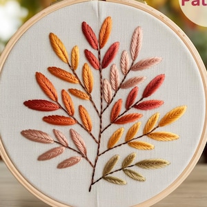 May include: Embroidered leaf design in a wooden hoop. The leaves are in shades of red, orange, yellow, and pink. The text "PDF Pattern" is in a circle in the upper right corner. The text "LilabyM" is in the lower left corner.