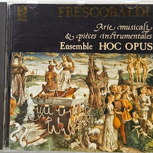 May include: A CD case featuring the album "Frescobaldi: Arie musicali & pièces instrumentales" by Ensemble HOC OPUS. The cover art is a Renaissance-style painting with figures and a landscape. The text is in gold lettering.