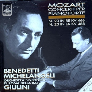 May include: CD case featuring a black and white image of a man, with the text "MOZART CONCERTI PER PIANOFORTE" and artist information. The CD case also includes the text "BENEDETTI MICHELANGELI" and "ORCHESTRA SINFONICA DI ROMA DELLA RAI GIULINI".
