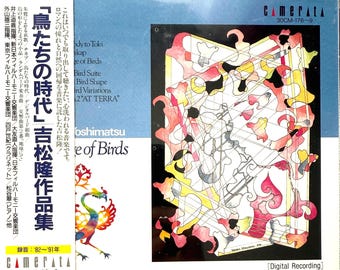 Può includere: Un cofanetto per CD con un design astratto colorato con forme rosse, gialle e nere. Il cofanetto per CD presenta testo giapponese e il titolo "L'Età degli Uccelli" di Takashi Yoshimatsu. È presente anche il logo Camerata.