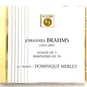 May include: A CD case with the name "JOHANNES BRAHMS" and the years "(1833-1897)". The text "SONATE OP. 5 RHAPSODIES OP. 79" is displayed. The CD case has a gold and white colour scheme with the Accord logo.