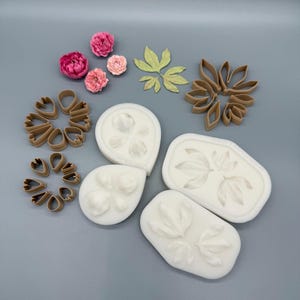 May include: A collection of crafting tools including three white silicone molds with petal and leaf impressions, four brown plastic petal and leaf cutters, three small pink peony-like flowers, and three light green leaf cutouts.