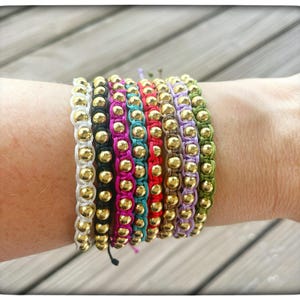 Macramé-woven bracelets with gold detailing. Adjustable to any size.