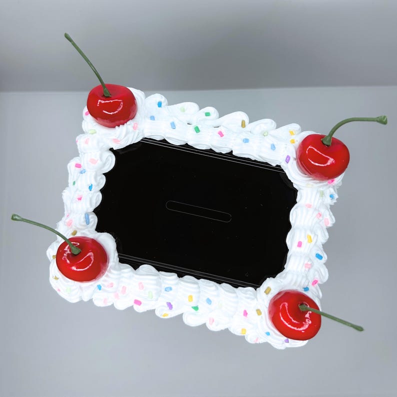 Top view of the black cake vault mini locker featuring white frosting outlines, rainbow sprinkles, and red cherries.