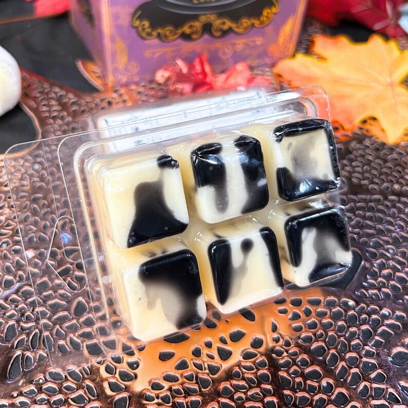 Back view of Other Mother wax melt showing black syrup-like swirl and black button accents on white square base, Coraline inspired spooky soy wax Halloween décor.