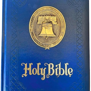 May include: A blue commemorative edition Holy Bible. The cover features a gold emblem of the Liberty Bell and text that reads "American Revolution Bicentennial Celebration 1776-1976 Commemorative Edition". The words "Holy Bible" are in gold script.