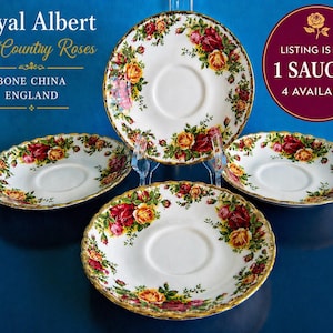 May include: Four white bone china saucers with a floral rose pattern in red, yellow, and pink, with gold trim. The saucers are from the Royal Albert Old Country Roses collection, made in England.