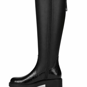 May include: A black knee-high boot featuring a smooth upper shaft and a textured crocodile-embossed pattern on the lower foot and heel area. The boot includes a full-length side zipper, a thick lug sole, and a small pull tab at the top rear.