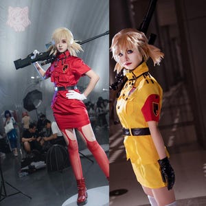 May include: Two cosplay outfits are displayed. One is a red military-style uniform with a short-sleeved shirt, skirt, and thigh-high stockings. The other is a yellow military-style uniform with a short-sleeved shirt and skirt. Both outfits have black belts.