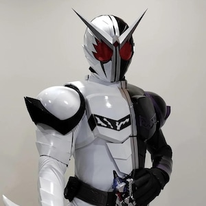 May include: A white and black superhero costume with a helmet featuring red eye coverings and silver accents. The costume has a split design, with one side white and the other black. The shoulders have large, rounded white armor pieces.